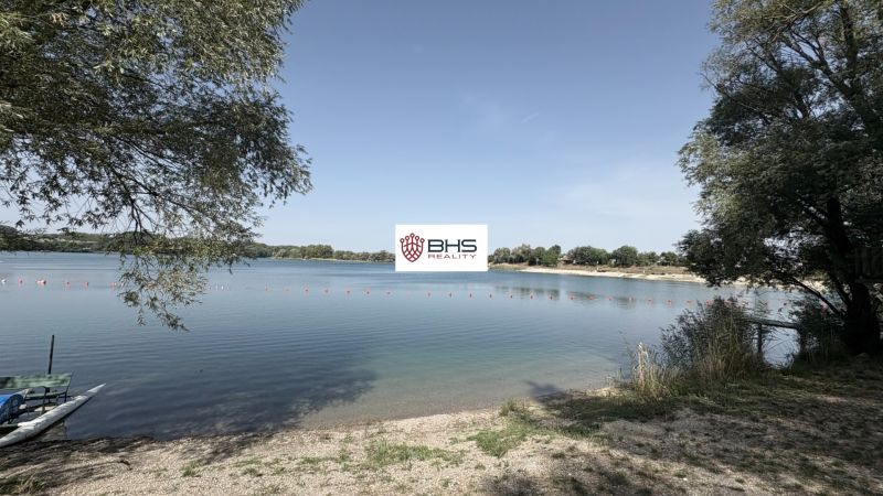 A lake in Bodíky with a shore, trees, and a boat, ideal for relaxing by the water.