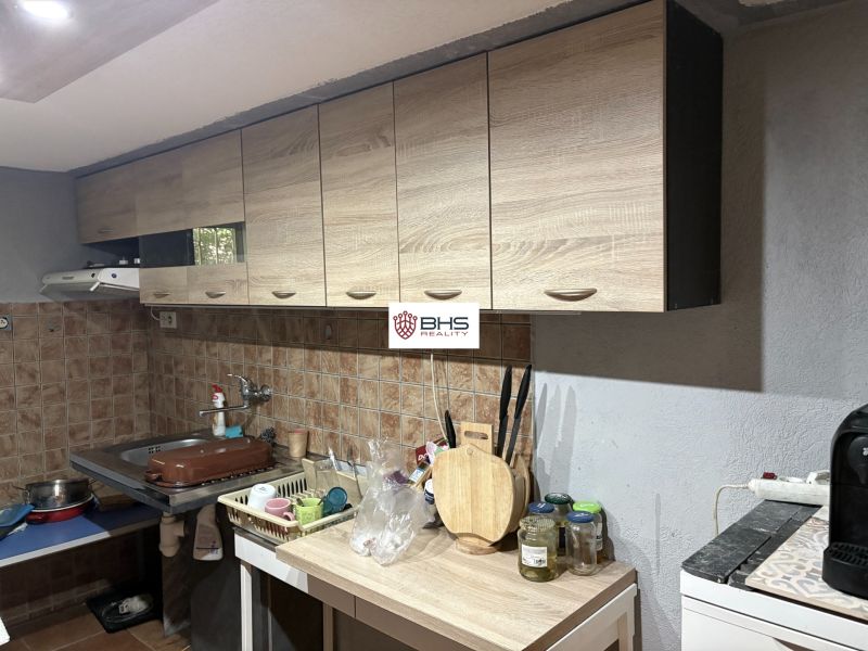 A kitchen in a cottage with a wood-decor floor and wooden cabinets.