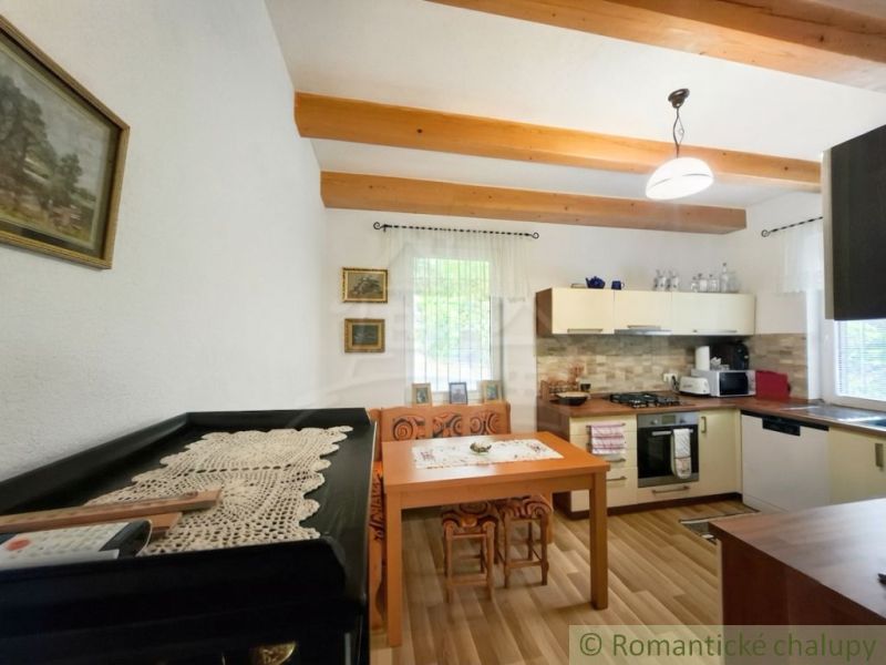 A kitchen in a cabin with wooden decor, traditional style, wooden beams, cozy atmosphere.