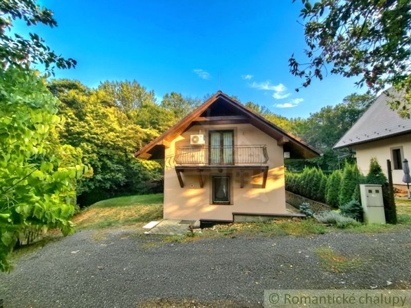 A cottage in Ružiná surrounded by greenery, with a balcony and air conditioning.