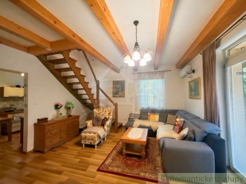 Living room in a cottage with wood-decor flooring and comfortable seating.