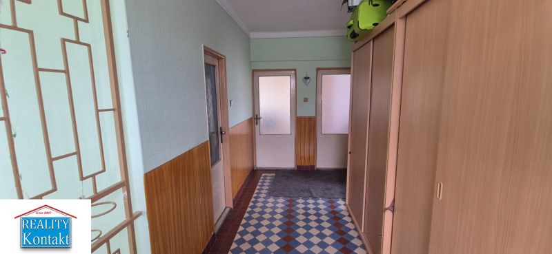 Hallway in a family house with an entrance door and a built-in wardrobe.