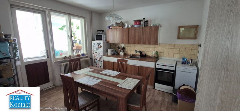 A kitchen in a family house with a dining table, white cabinets, and wooden decor.