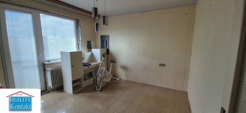 Exercise bike and furniture in a room of a family house with a wooden decor floor.