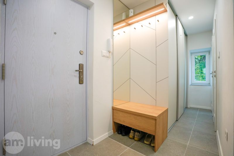 Entrance hallway in a 3-room apartment with a bench and a mirror.