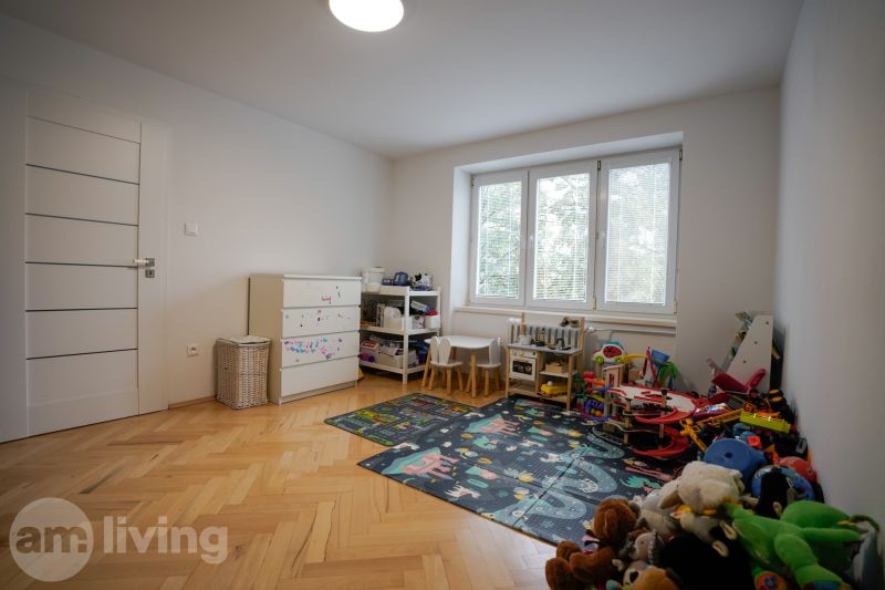 A children's room with toys, a carpet, and a wooden decor floor in a 3-room apartment.