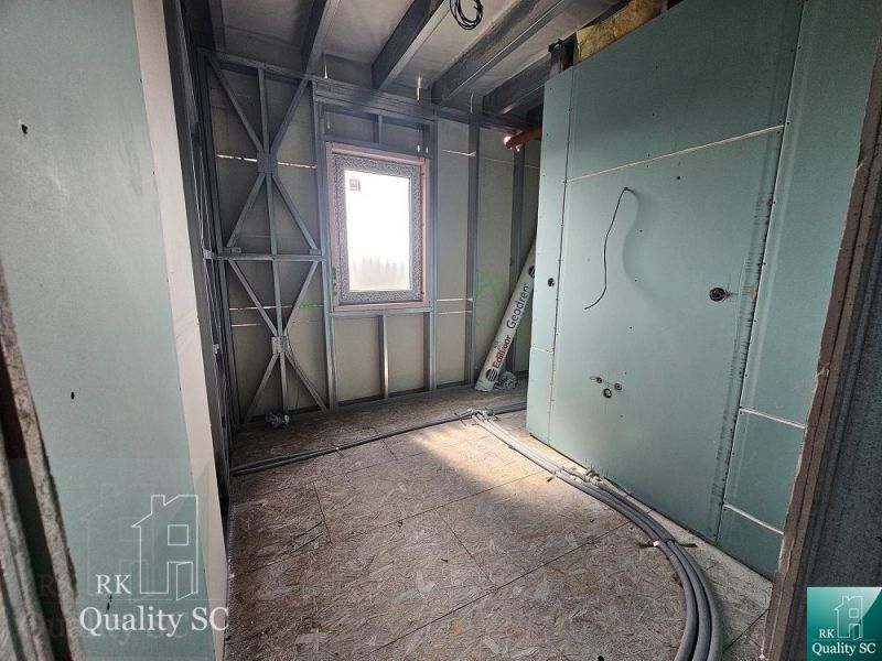 Interior construction of a family house in the renovation stage with a window and cables.