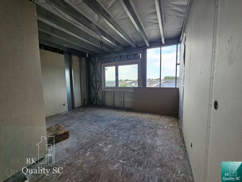 Construction site inside a family house with a view through a large window.