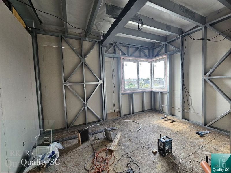 Interior of a family house under construction with a metal structure and a window with a view.