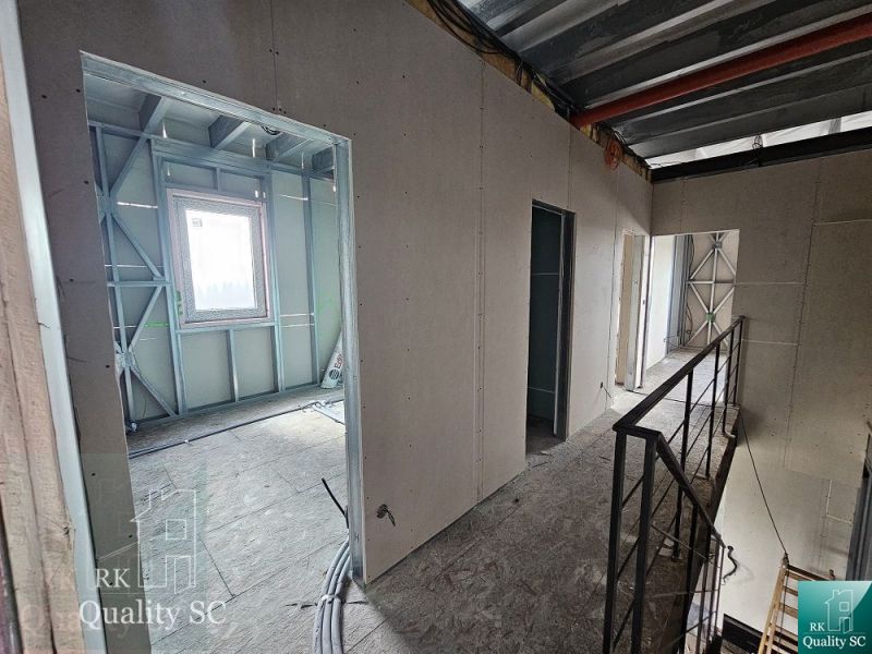 The interior of a family house with metal frames and a concrete floor.