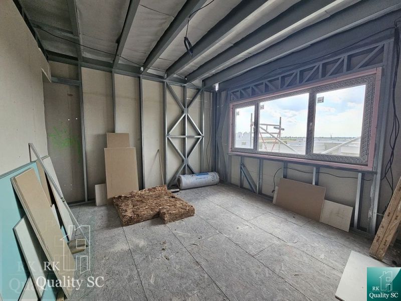 Building material in a room of a family house with a view through a large window.