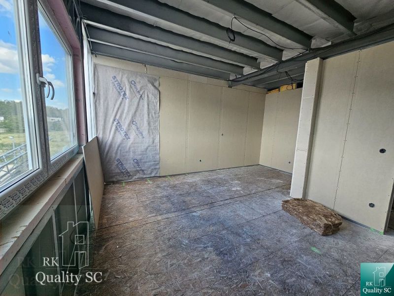 The interior of a family house with unfinished flooring and drywall walls.