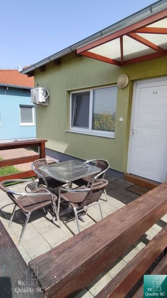 Garden terrace of a one-room apartment in Boldog with seating by the green house.