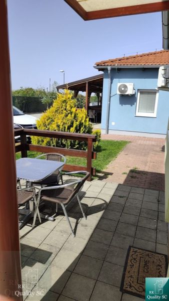 Garden with a terrace and table in front of a blue building in Boldog, 1-room apartment.