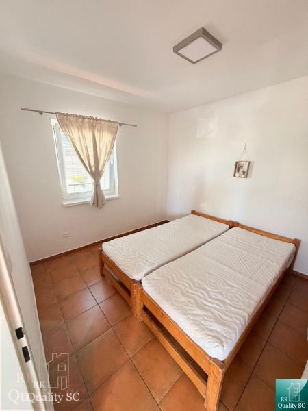 Bedroom in a one-room apartment with a double bed and tiles.