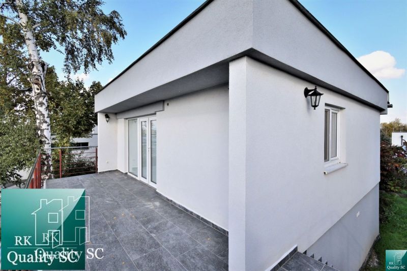 Terrace by the cottage in Senec at SUNNY LAKES SOUTH with a white facade and trees.
