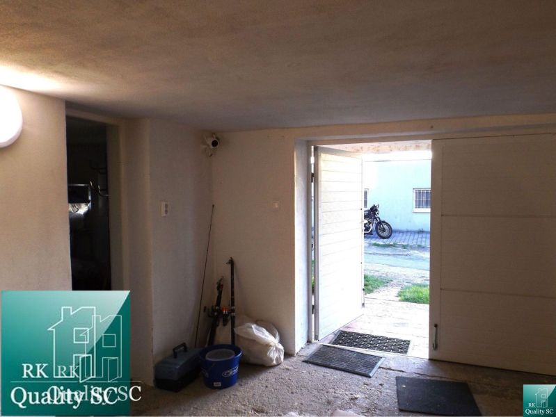 An open garage at the cottage with tools and a view of the motorcycle.