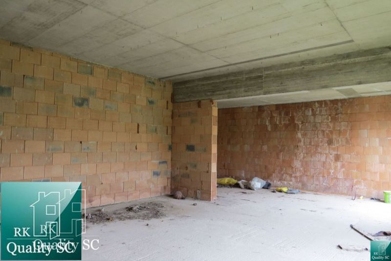 Brick construction in the interior of a family house with a concrete ceiling and cleaning tools.