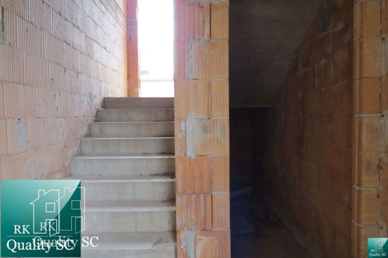 In the family house, concrete stairs and brick walls without plaster can be seen.