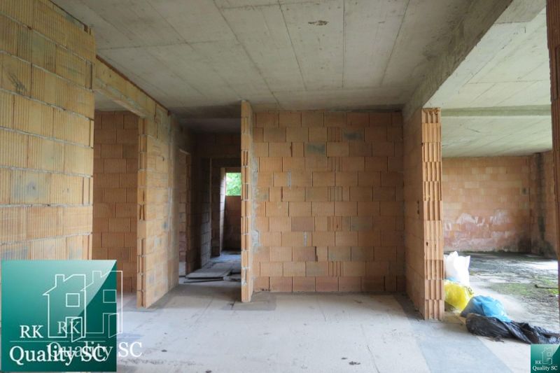The interior of a family house under construction with exposed brick walls.