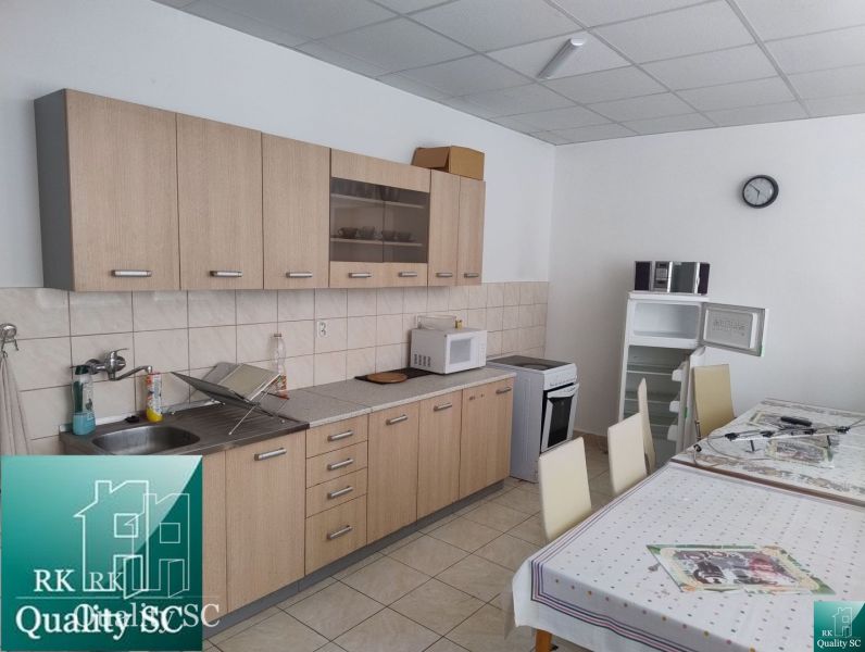 A kitchen unit and table in production premises with tiles and appliances.