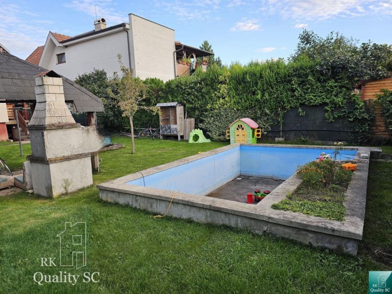 A garden with a swimming pool on the property of a family house in the town of Tureň, on Tureň street.