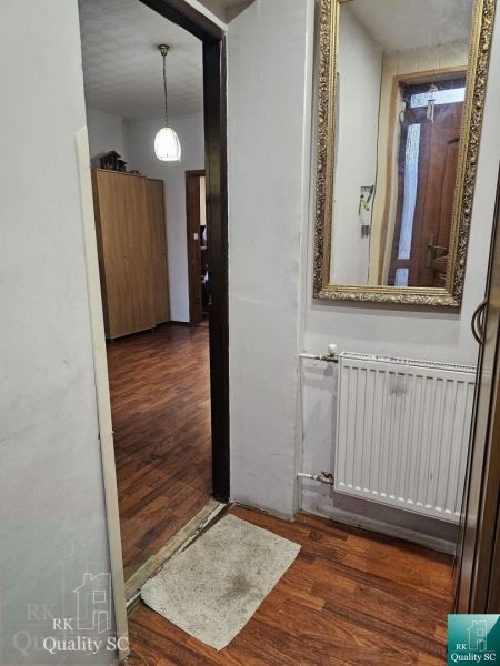 Interior of a family house with a wooden decor floor, mirror, and lighting.