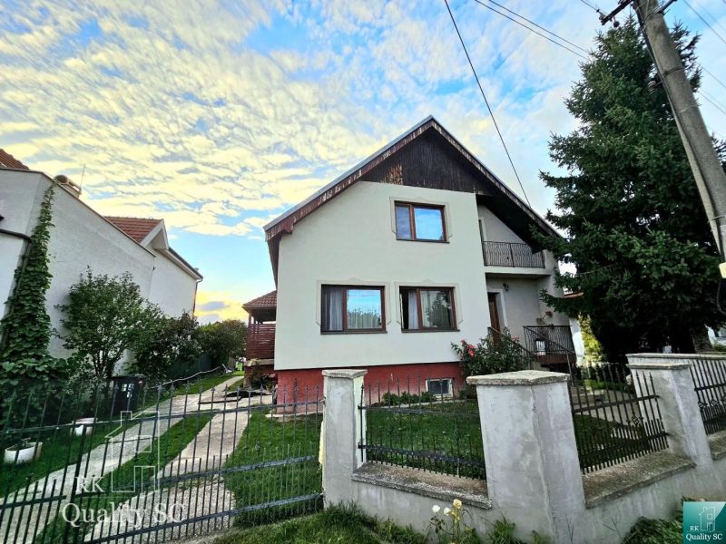 A family house in Tureň on Tureň Street surrounded by a garden and a blue sky.