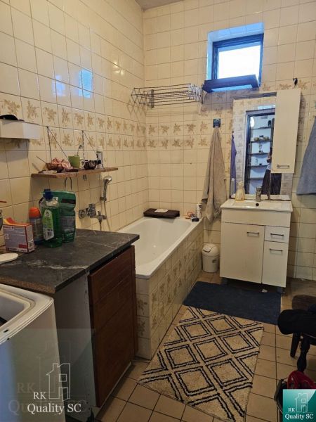 Bathroom with a bathtub and cabinets in a family house.