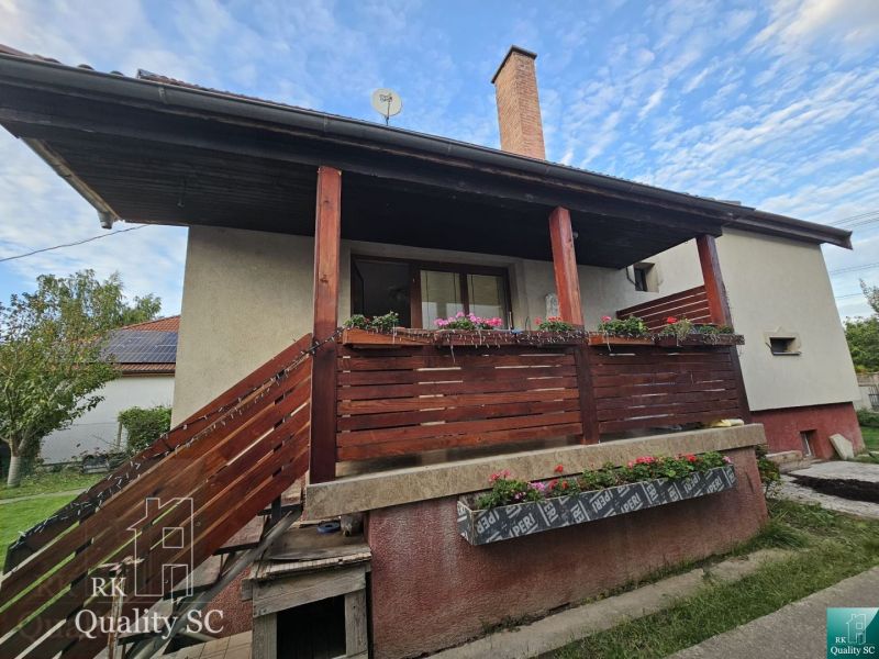 A family house in the village of Tureň on Tureň Street with a wooden terrace and railing.