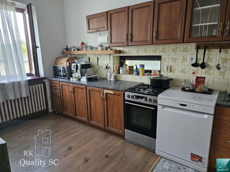 A kitchen in a family house with wooden decor, cabinets, stove, dishwasher.