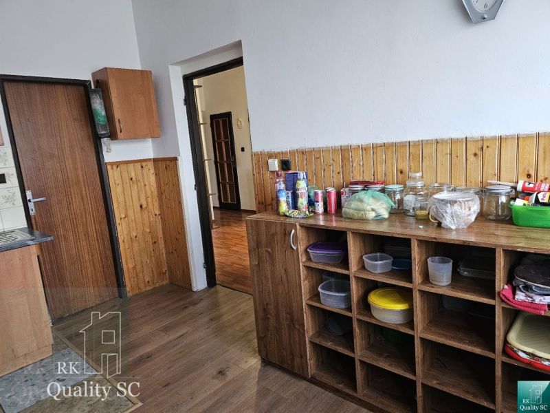A kitchen in a family house with a wooden decor floor and storage shelves.