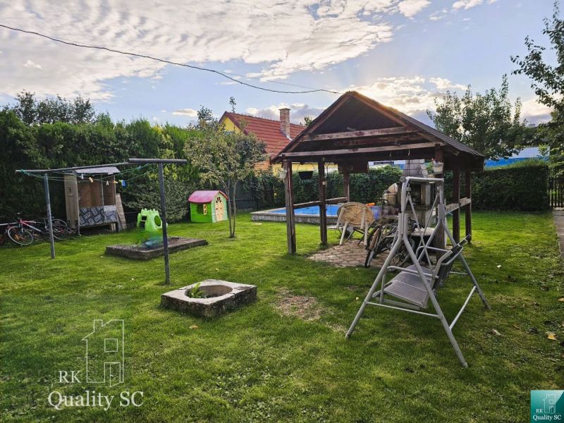 The garden of a family house on Tureň Street in Tureň with a gazebo, a swing, and a children's playground.