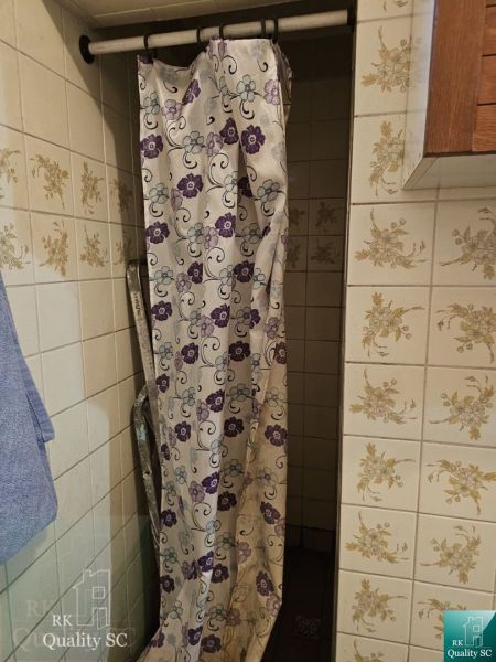 Bathroom in a family house with a shower and floral tiles.