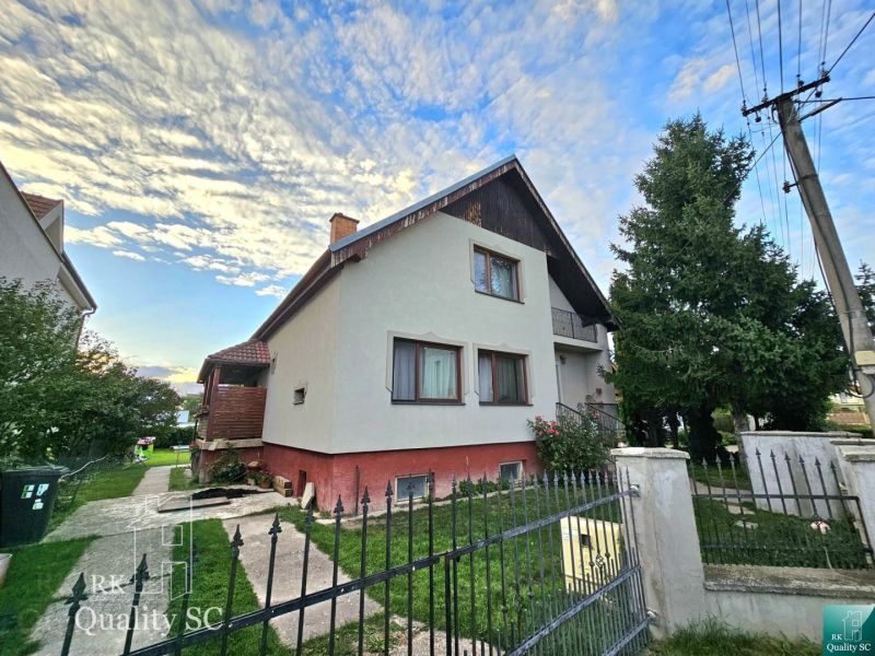 A family house on a street in Turany with a spacious garden and a concrete walkway.