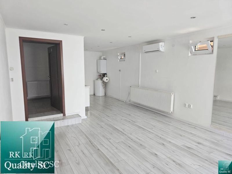 Commercial premises with wood decor flooring, air conditioning and boiler, room with radiator.