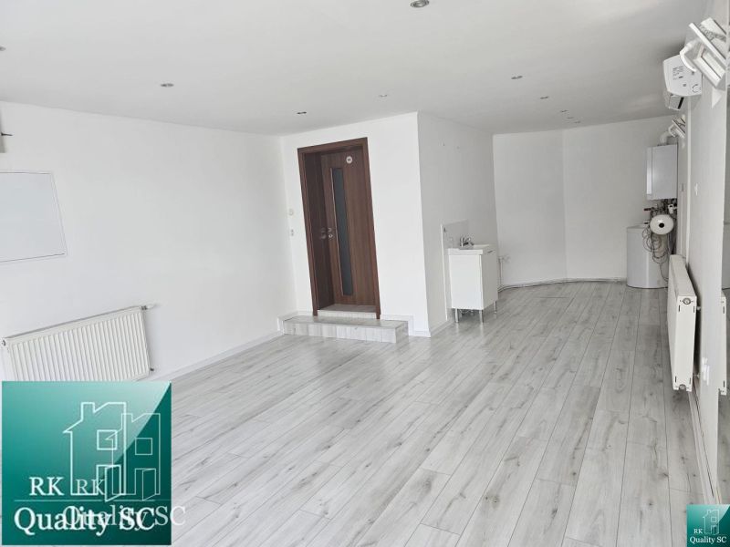 Commercial spaces with white walls and wood-patterned flooring.