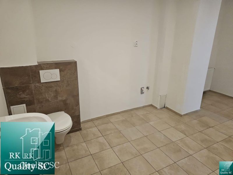 A toilet with tiles and ceramic flooring in commercial premises.