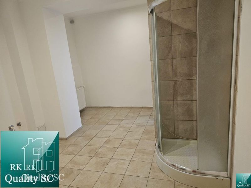 Tiling and shower corner in commercial premises with neutral walls.