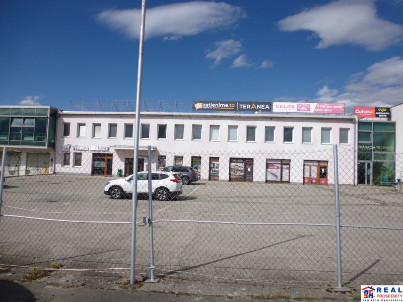 Commercial premises on Strojnícka Street in Prešov with a concrete parking lot and company signs.