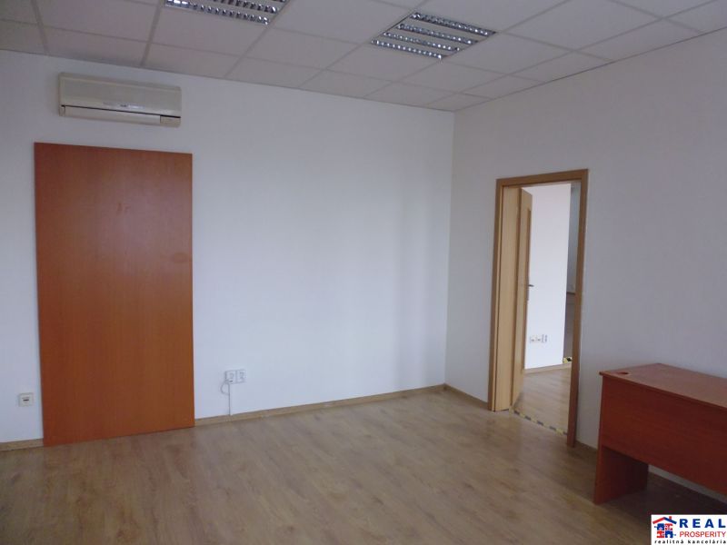 Commercial premises with white walls, wood-patterned flooring, and air conditioning.