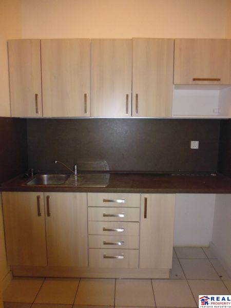 Kitchen unit in commercial premises with wooden decor and tiled flooring.