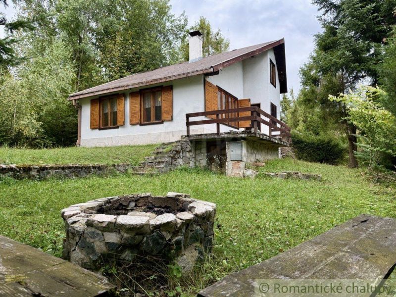 A cottage in Košická Belá with a fireplace in the middle of a green lawn.