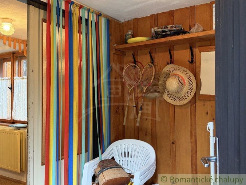 The interior of a cabin with colorful stripes, hats, and rackets on the wooden wall.