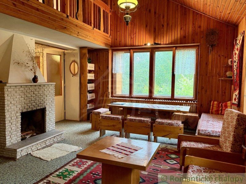 A cottage with wooden paneling, a fireplace, and textiles with folk motifs.