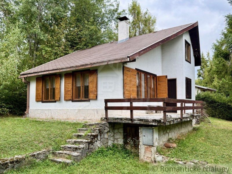 A cottage in Košická Belá with a stone staircase and wooden shutters in a natural setting.