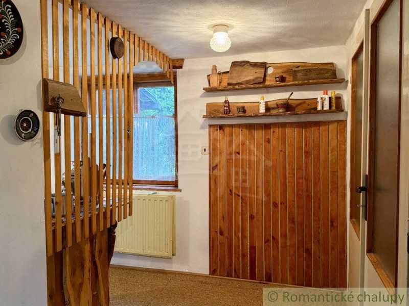 Interior of a cabin with wooden decoration and a shelf with traditional elements.