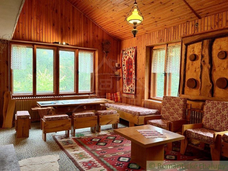 The interior of the cabin with wooden floor decor, colorful rugs, and wooden furniture.