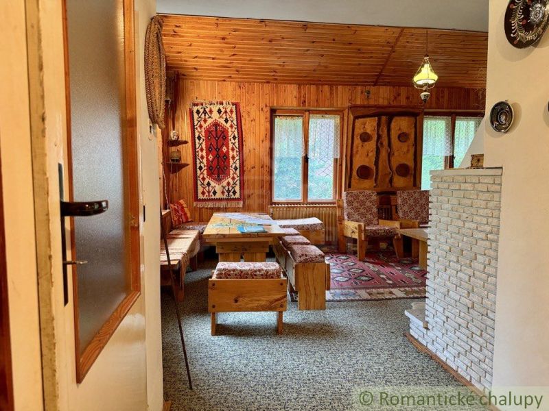 A cottage with wooden decor, carpet, and rustic wooden furniture, decorative carpet on the wall.