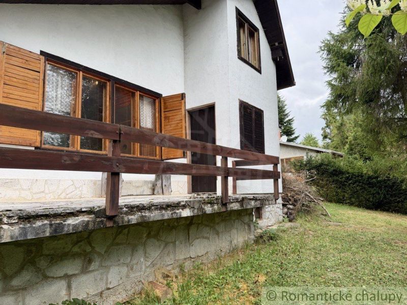 A cottage in Košická Belá with wooden shutters and a stone base.